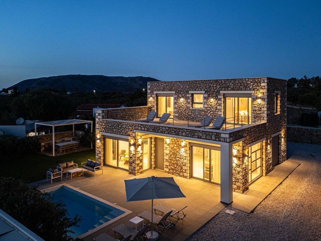 Maes Villa Crete am Abend mit privatem Pool und beleuchteter Steinfassade
